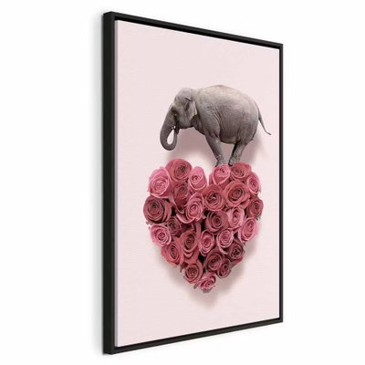Elephant lover elephant amid – svart ram. En liten grå elefant balanserar över ett hjärta av täta rosa rosor mot en ljusrosa bakgrund.