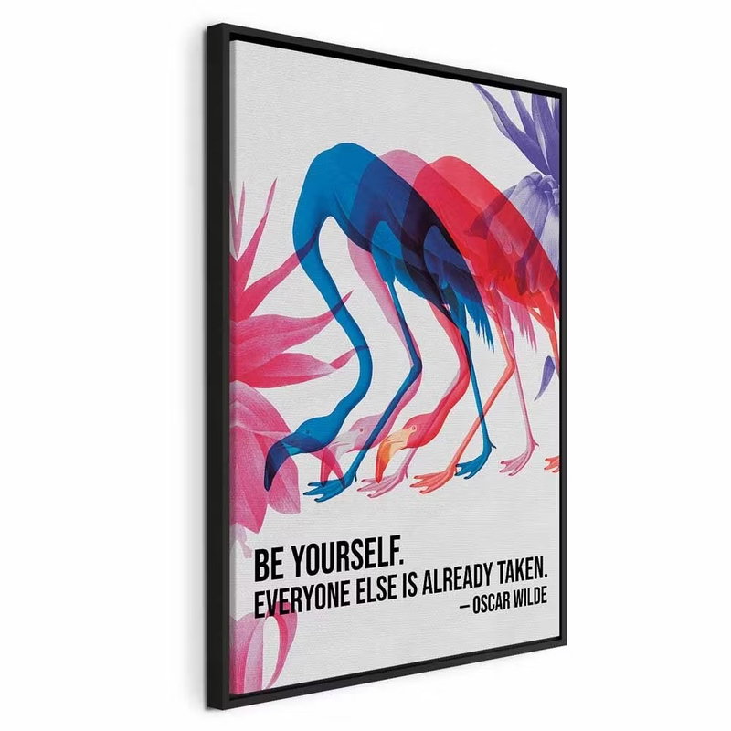 Colorful flamingos – svart ram. Rosa, blå och röda flamingoliknande fåglar böjer långa halsar över det engelska citatet Be yourself.