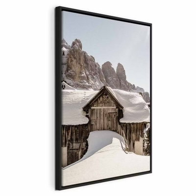 Winter in the dolomites – svart ram. En mörk trästuga ligger inbäddad i snö nedanför höga, klippiga bergstoppar.