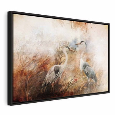 Herons on the hunt wide – svart ram. Två gråvita hägrar står i högt gräs återgivet med lösa penseldrag i brunt, orange och crème.