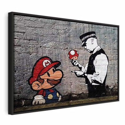 Mario and cop by banksy – svart ram. En rödklädd spelfigur möter en svartvit polis och en liten svamp mot en tryckt grå tegelvägg.