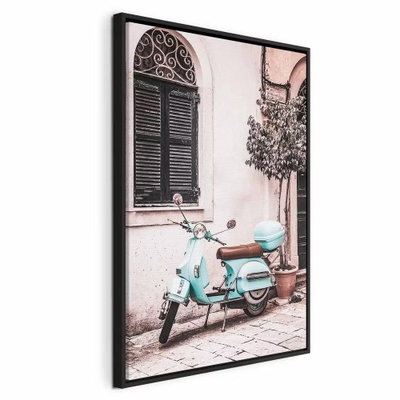 Iconic vespa vertical – svart ram. En turkos skoter står parkerad framför en ljusrosa husvägg med mörka fönsterluckor.