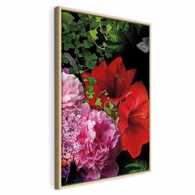 Floral symphony vertical – naturfärgad ram. Stora röda och rosa blommor med tätt grönt bladverk fyller en närbild mot mörk bakgrund.