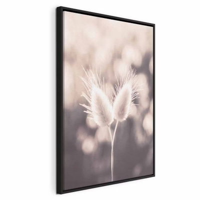 Land of gentleness vertical – svart ram. Mjuka vita fröställningar på tunna stjälkar framträder mot en suddig bakgrund i beige och grått.