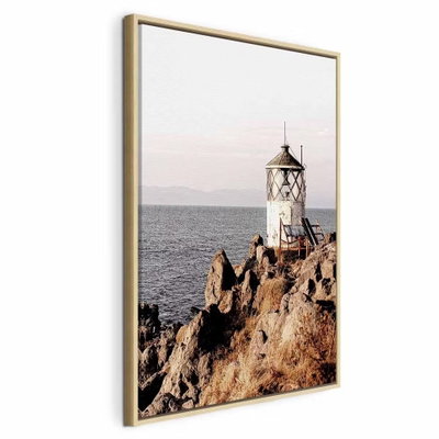 Lantern on the cliff – naturfärgad ram. En liten vit fyr står på en brant klippa vid ett lugnt hav under en ljus himmel.