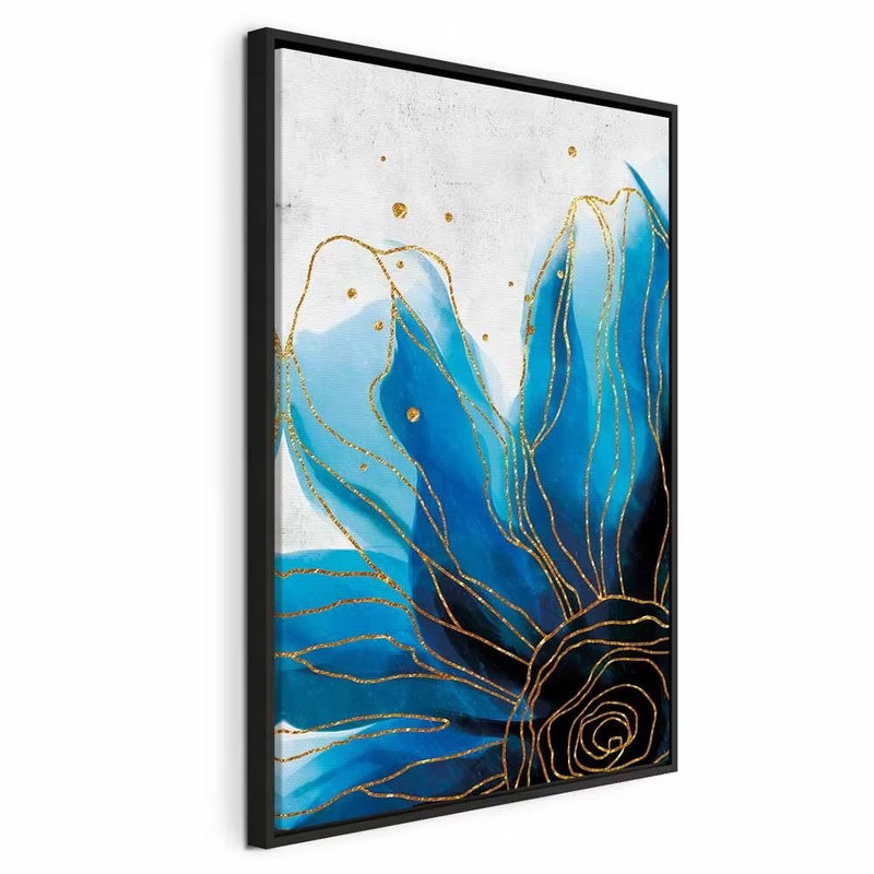 Enchanted flower vertical – svart ram. Stora blå kronblad och en mörk spiralformad mitt lyfts av tunna guldfärgade konturer på vitt.