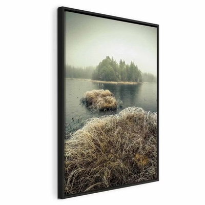 Autumn in the wetlands – svart ram. Små bruna gräsöar ligger i stilla vatten framför en mörk trädridå under en ljust grönaktig dimhimmel.