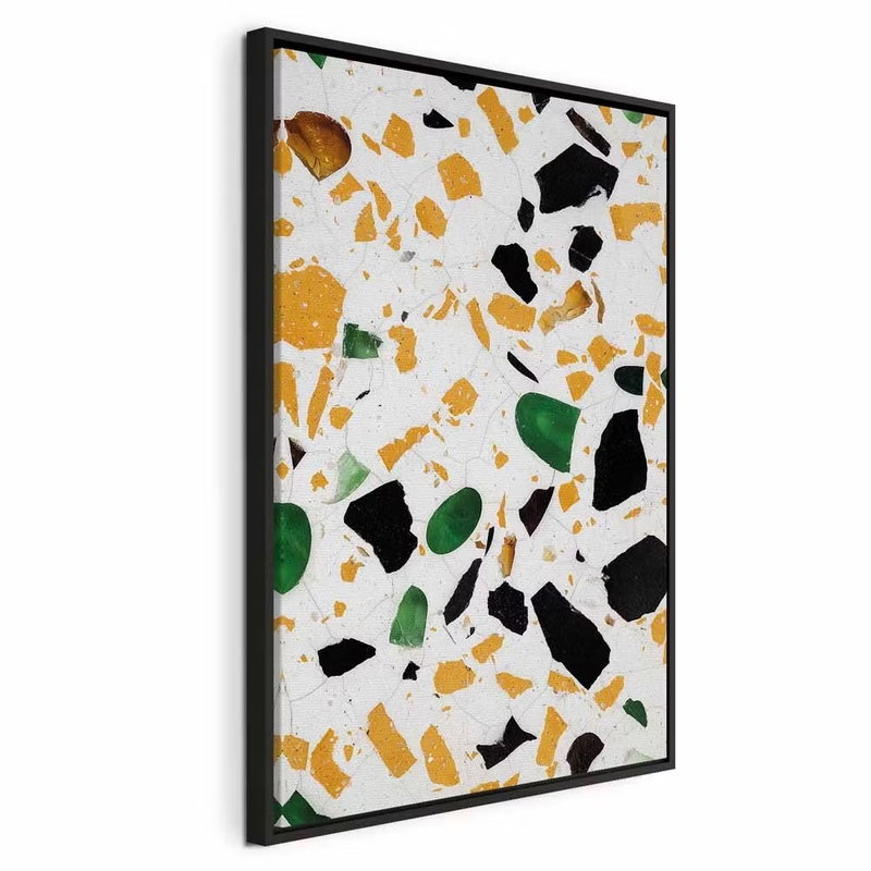 Terrazzo vertical – svart ram. Oregelbundna fält i ockra, svart och grönt sprids över vitt i ett tryckt terrazzomönster.