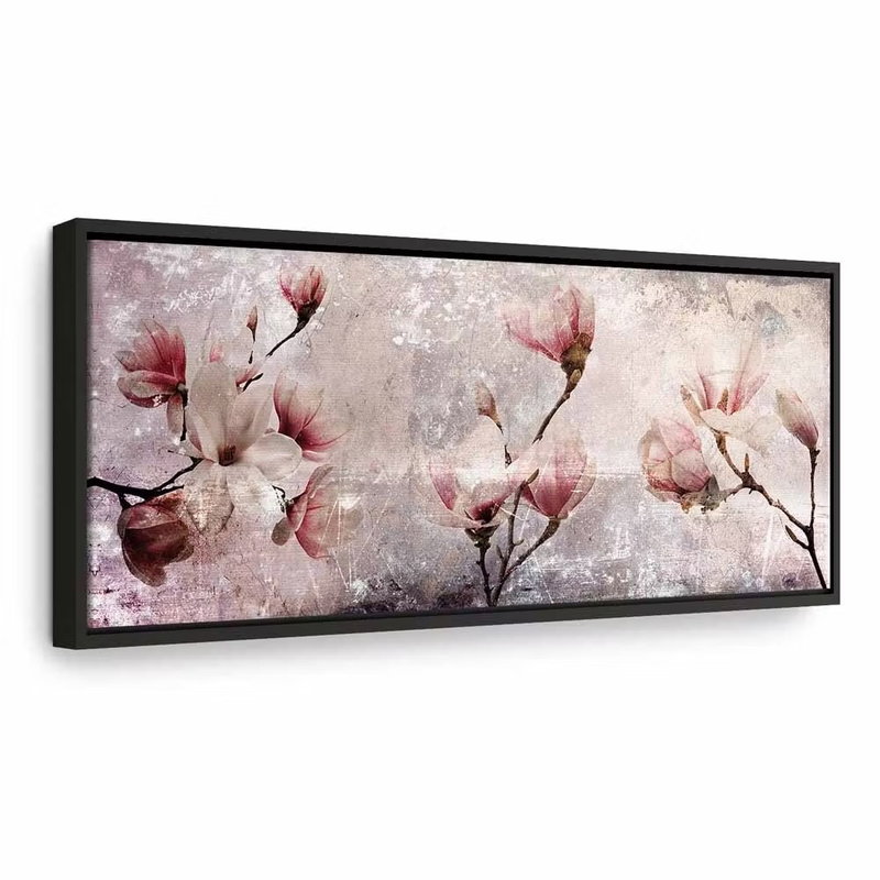 Magnolia charm narrow – svart ram. Ljusa rosa magnoliablommor sitter på mörka grenar över en vit och grå, målerisk bakgrund.