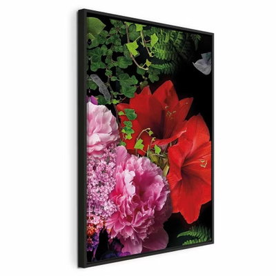 Floral symphony vertical – svart ram. Stora röda och rosa blommor med tätt grönt bladverk fyller en närbild mot mörk bakgrund.