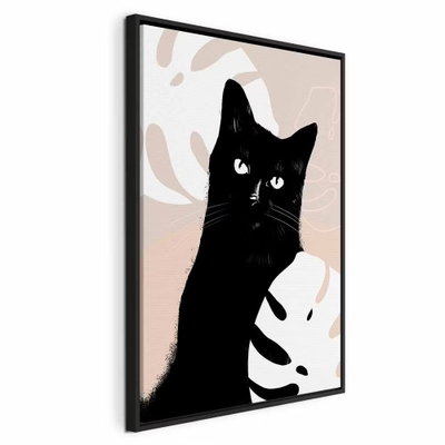 Cat in monsteras vertical – svart ram. En svart katt med ljusa ögon tittar fram mellan stora crèmefärgade blad på rosa och beige botten.