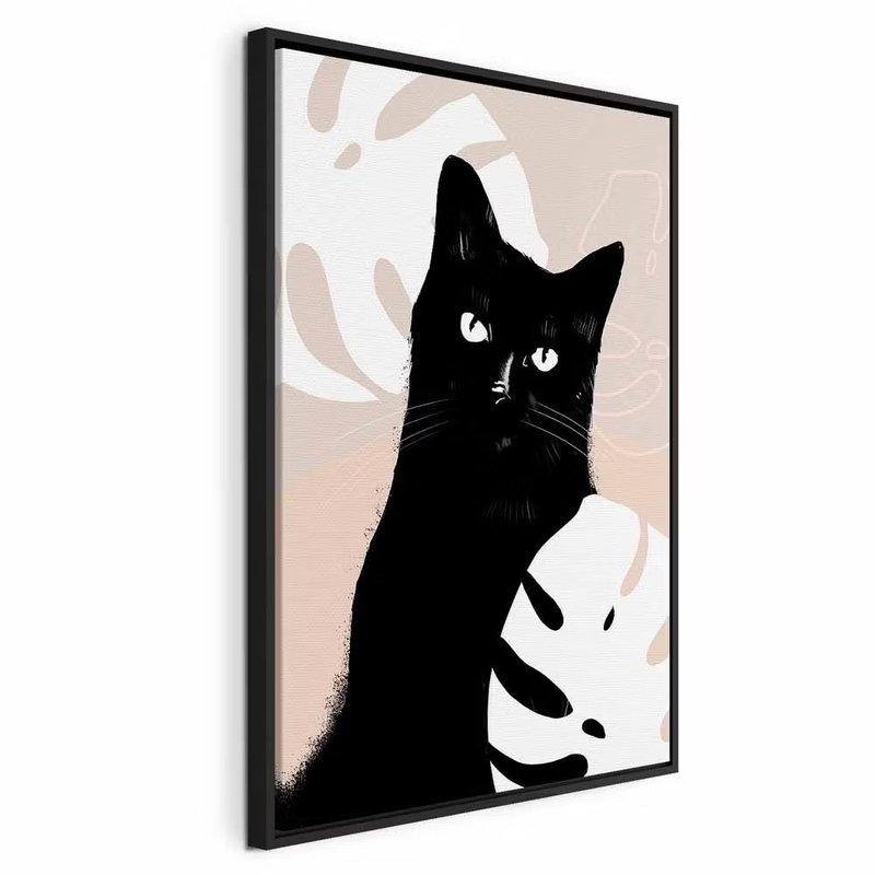 Cat in monsteras vertical – svart ram. En svart katt med ljusa ögon tittar fram mellan stora crèmefärgade blad på rosa och beige botten.