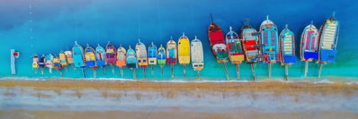 Colourful boats narrow – motivvy. Små båtar i rött, gult, blått och turkost ligger i en lång rad mot en blå vattenyta.