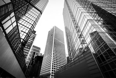 In a big city wide second – motivvy. Höga glasfasader ses underifrån i svart och vitt med raka linjer mot en ljus himmel.