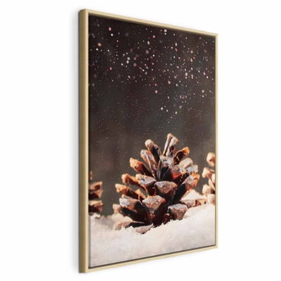 Winter pine cone vertical – naturfärgad ram. En brun tallkotte ligger på snö mot en mörk bakgrund med ljusa, glittrande detaljer.