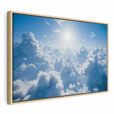 Heavenly calm warm rays of – naturfärgad ram. Täta vita moln breder ut sig under en klarblå himmel med starkt solljus högt i bilden.
