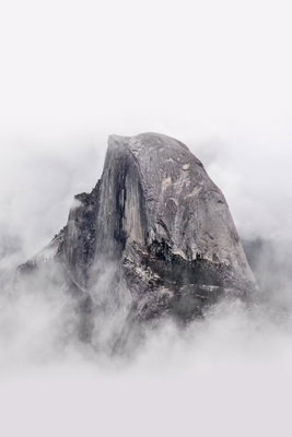 Half dome vertical – motivvy. En brant, rundad grå klippformation höjer sig ur ett tätt lager av vita moln.