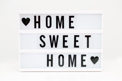 Cinema light box vertical – motivvy. En vit ljusskyltsliknande bild med svarta bokstäver och små hjärtan visar orden HOME SWEET HOME.