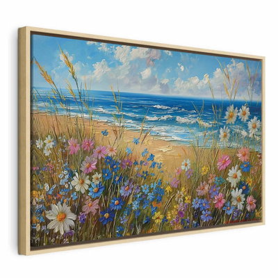 Seascape wildflowers and a – naturfärgad ram. Vita, rosa och blå ängsblommor växer framför en sandstrand och ett blått hav under ljus molnhimmel.