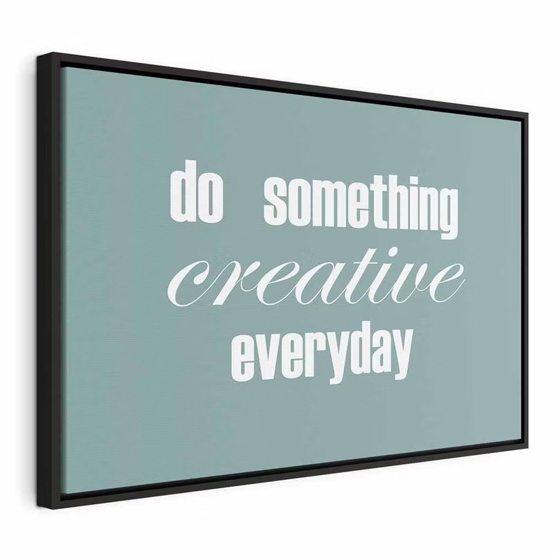 Do something creative – svart ram. Vit typografi med orden do something creative everyday står mot en jämn, dämpat blågrön bakgrund.
