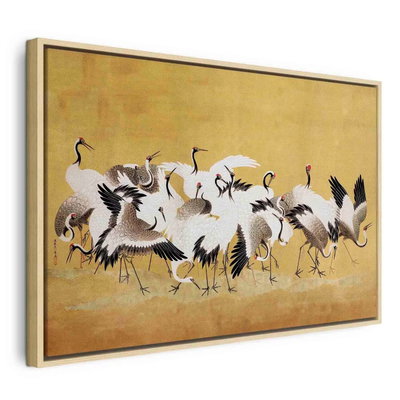 Japanese cranes a flock of – naturfärgad ram. En flock långbenta svartvita fåglar med röda detaljer samlas mot en varmt guldfärgad bakgrund.