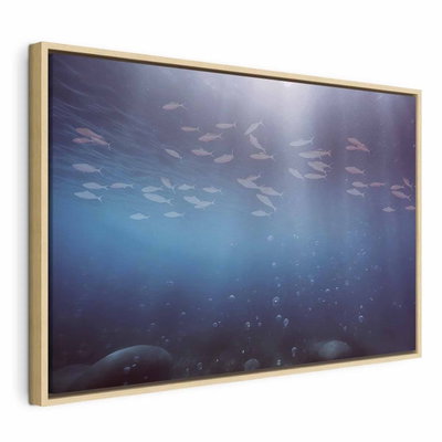 Fish in the depths – naturfärgad ram. Ett ljust fiskstim rör sig över bildens övre del i ett mörkblått undervattensmotiv med mjuka ljusstrålar.