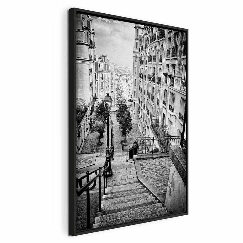 Parisian suburb vertical – svart ram. En lång trappa med mörkt räcke leder ned mellan täta husfasader i en svartvit stadsbild.
