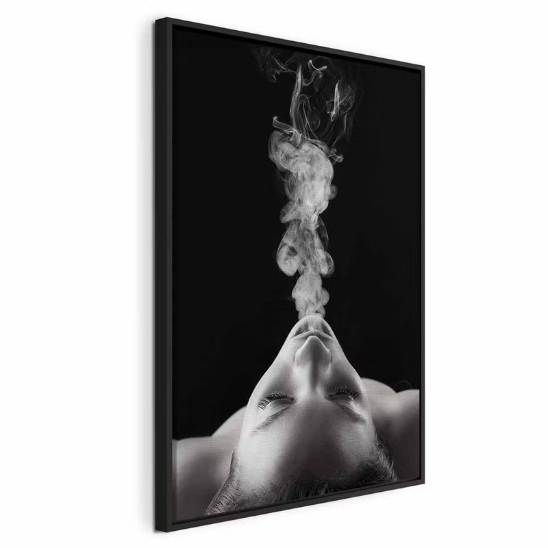 Smoke cloud vertical – svart ram. Ett ansikte lutar bakåt medan en ljus rökpelare stiger upp mot en svart bakgrund.