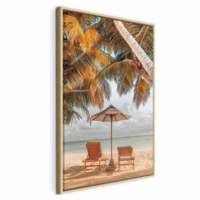 Palm umbrella vertical – naturfärgad ram. Två trästolar och ett parasoll står på en sandstrand under höga palmer vid ett ljust hav.