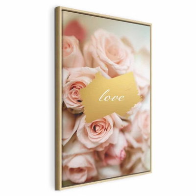 One feeling vertical – naturfärgad ram. Mjukt rosa rosor omger ett litet guldfärgat textfält med ordet love.