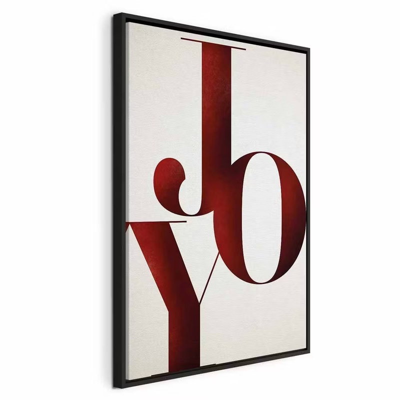 Joy vertical – svart ram. Stora mörkröda bokstäver med ordet JOY bildar en lodrät komposition på en ljus botten.