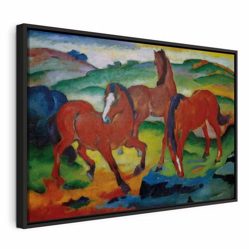Franz marc the red horses – svart ram. Tre röda hästar står i ett böljande landskap med gröna kullar, blå skuggor och gula markpartier.