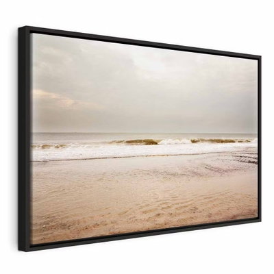 Sea after storm wide – svart ram. Små vågor möter en bred sandstrand under en stor, ljus himmel i beige och grå toner.