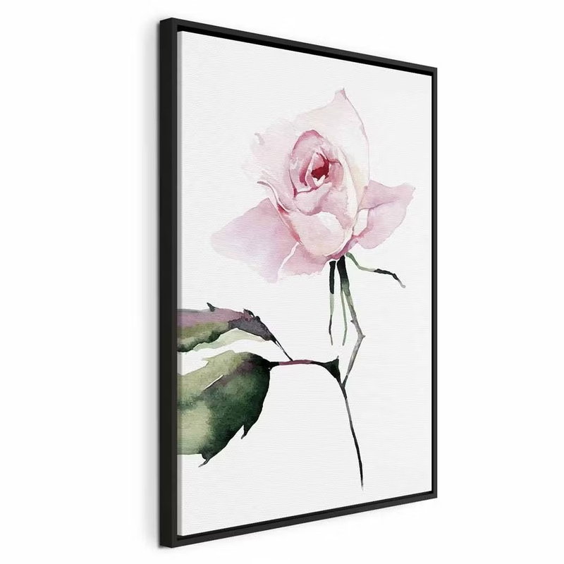 Lonely rose vertical – svart ram. En blekt rosa ros med gröna blad tecknar sig i ett mjukt målat motiv mot vitt.