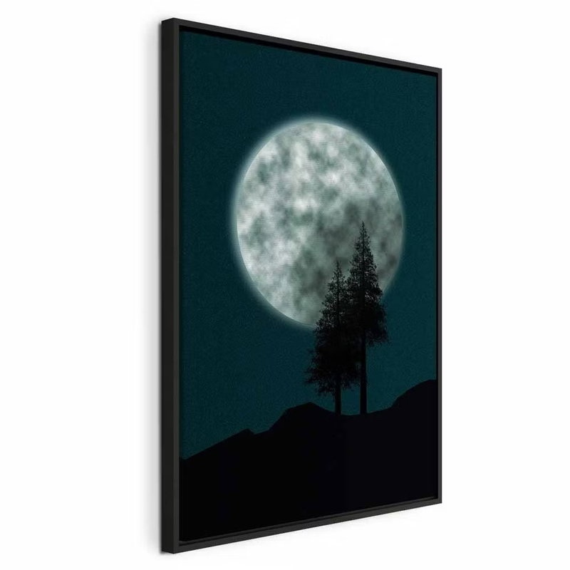 Beautiful full moon vertical – svart ram. En stor ljus fullmåne hänger ovan mörka kullar och två smala barrträd mot en djup blågrön himmel.