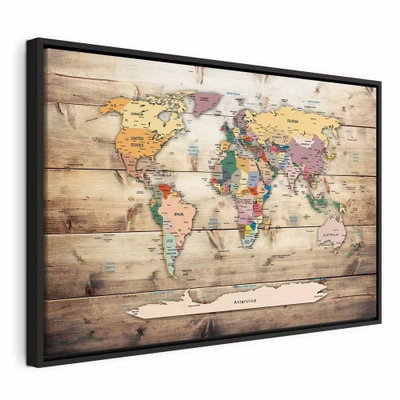 World map colourful – svart ram. Länder i milda pastellfärger ligger över en tryckt bakgrund av horisontella bruna träplankor.