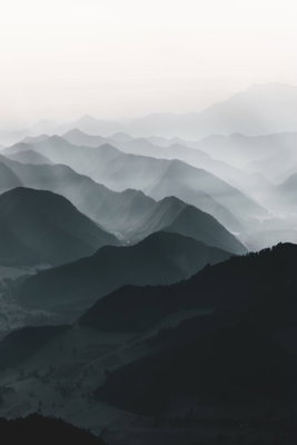 Parallel ridges vertical – motivvy. Många mörka bergsryggar överlappar varandra och ljusnar mot en dimmig horisont.