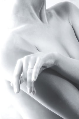 Feminine delicacy vertical – motivvy. En ljus hand vilar mot en naken axel i ett mjukt beskuret svartvitt fotografi.