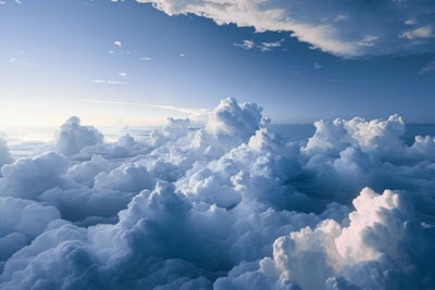 Aerial landscapes rays – motivvy. Ett vidsträckt lager av vita och blåskuggade moln sträcker sig mot en ljusblå himmel.