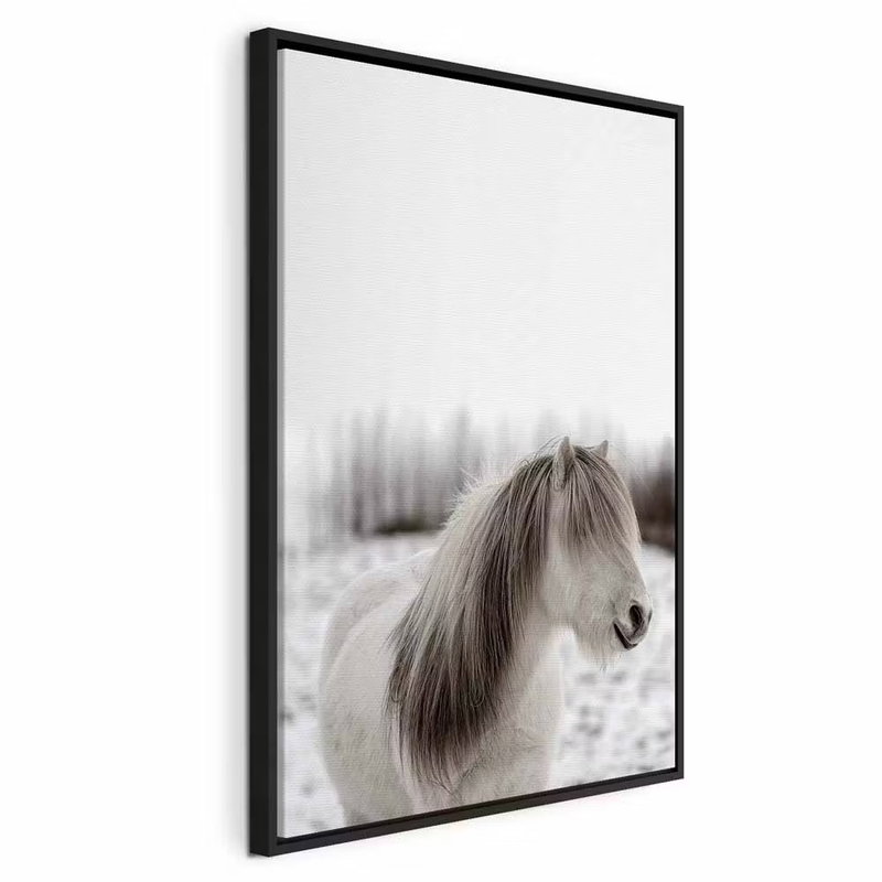 Horse mane vertical – svart ram. En liten ljus häst står i ett snötäckt landskap med en lång gråbrun man över ansiktet.