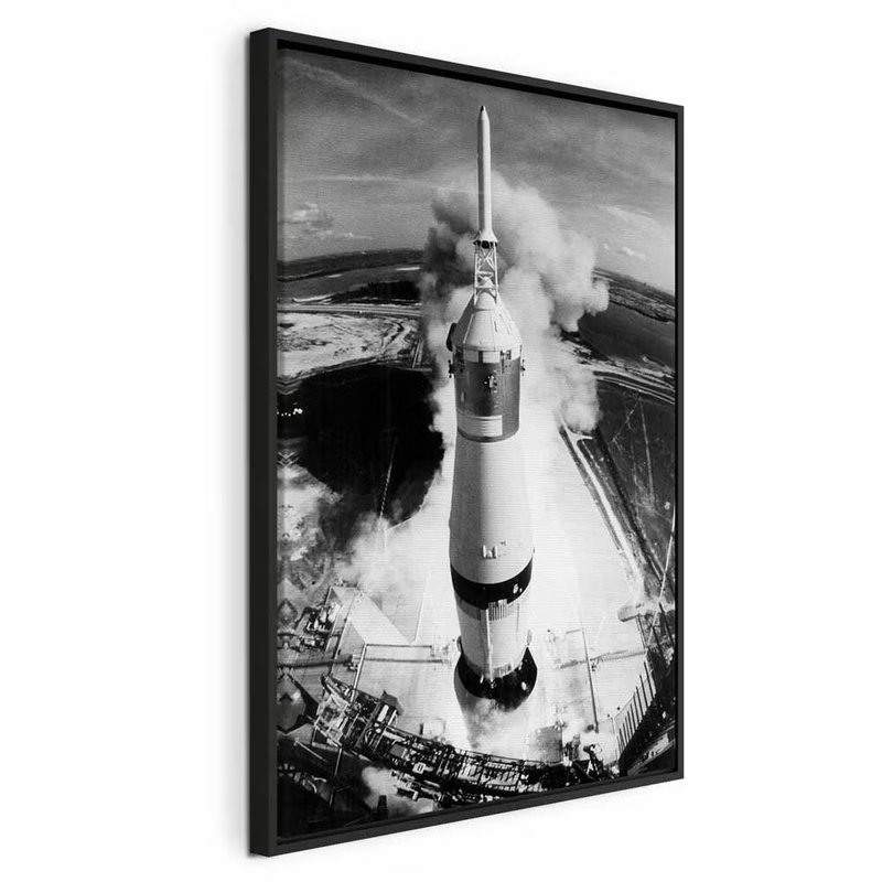 Cosmic speed vertical – svart ram. En hög vit raket står på en uppskjutningsplats omgiven av rök, tekniska konstruktioner och mörka markytor.
