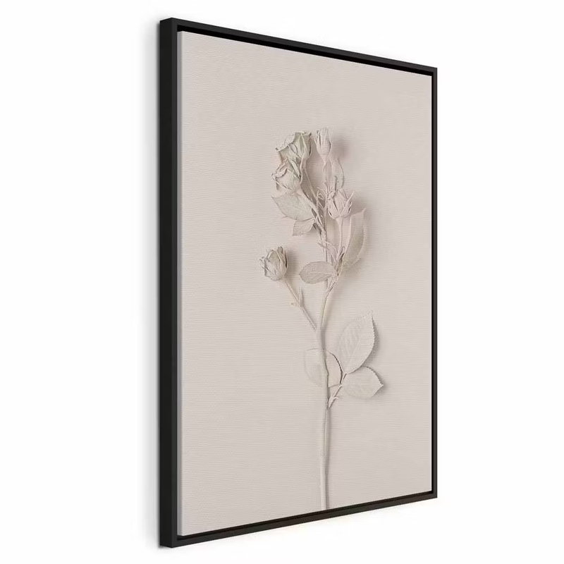 Harmonious rose vertical – svart ram. En ljus ros med tunna blad och stjälk framträder mot en beige botten. Reliefkänslan återges i själva trycket.
