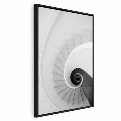 White stairs vertical – svart ram. En vit trappa vrider sig runt en mörk mittpunkt. Räcken och steg ger bilden ett tydligt geometriskt djup.
