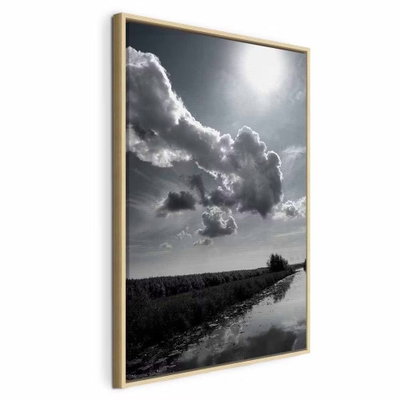 Sun over clouds sky – naturfärgad ram. En stor sol och kraftiga moln ligger över en låg landskapshorisont i en kontrastrik svartvit bild.