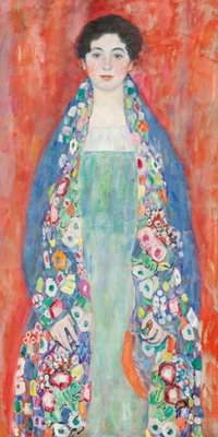 Gustav klimt portrait of – motivvy. En mörkhårig kvinna i en lång, mönstrad och färgrik dräkt står mot en kraftigt röd bakgrund.