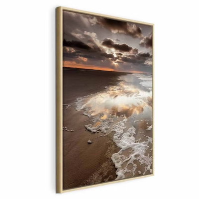 Present distraction vertical – naturfärgad ram. Vita vågor rullar in över en sandstrand under en dramatisk molnhimmel med ett smalt varmt ljus vid horisonten.