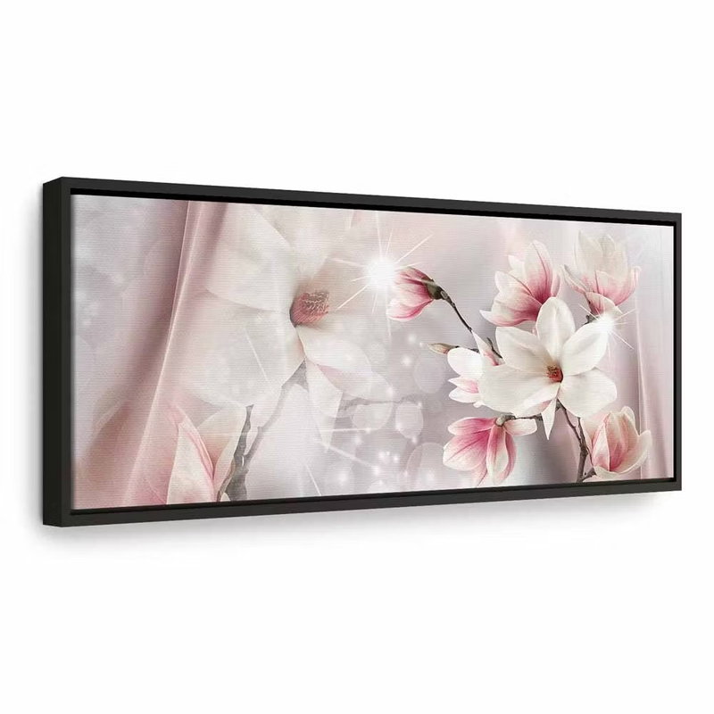 Magnolia reflection narrow – svart ram. Vita och rosa magnoliablommor möter mjuka tygformer och ljusa glittrande detaljer på en blek bakgrund.