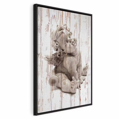 Pensive cupid vertical – svart ram. En liten ljus figur i eftertänksam ställning återges över en tryckt bakgrund av slitna vita brädor.