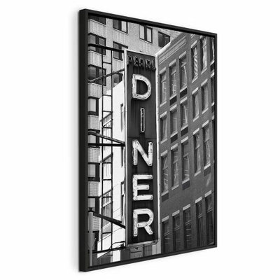 New york neon sign vertical – svart ram. En hög DINER-skylt hänger mellan täta husfasader i en svartvit gatubild.
