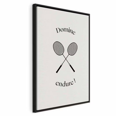 Black badminton rackets – svart ram. Två grå racketar ligger mellan de svarta orden Domine och endure! på en ljus crèmefärgad botten.